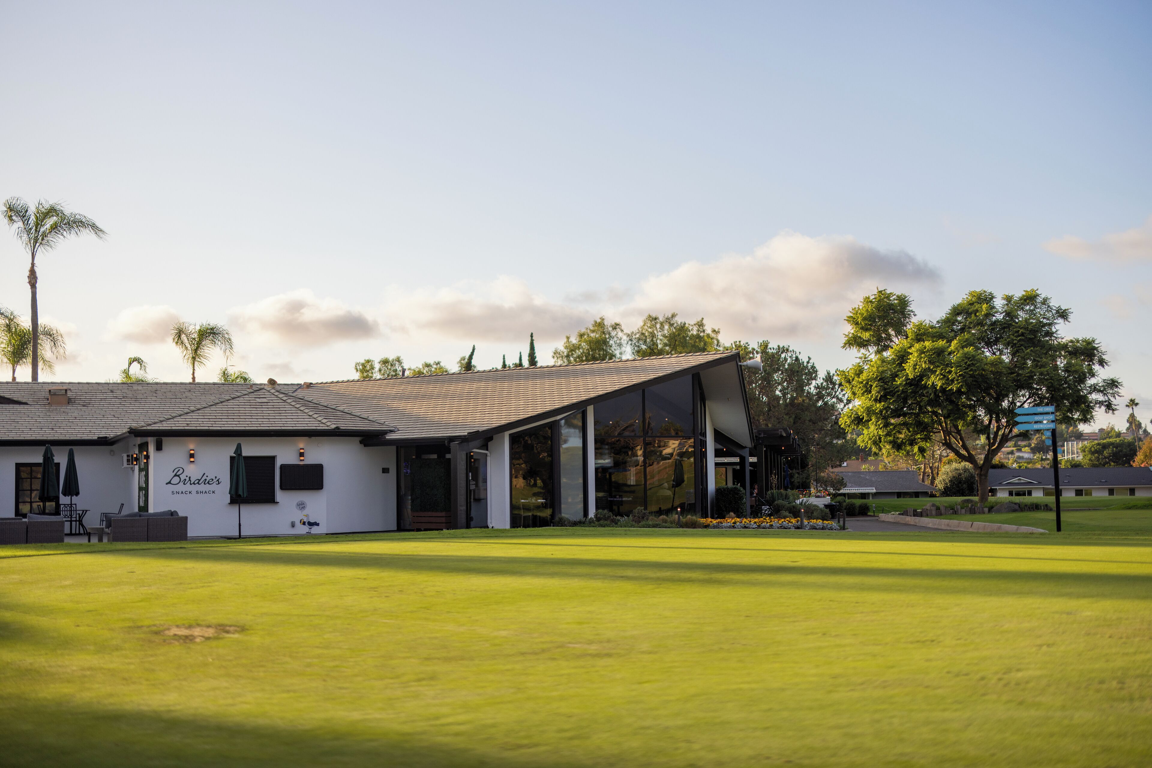 A building with a sign reading "Birdie's Snack Shack" in front of a well-maintained lawn.