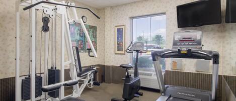 A gym with a treadmill, weight machines, and a stationary bike.