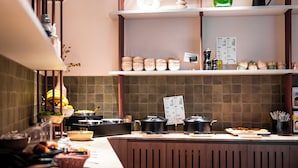 A kitchen area with a buffet setup, including various food items and cooking equipment. - Leonardo Hotel Hengelo City Center (Hengelo)