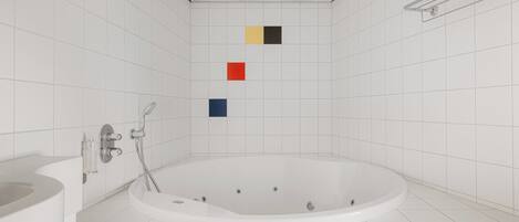 Un baño moderno con una bañera independiente, un lavamanos y un perchero para toallas.