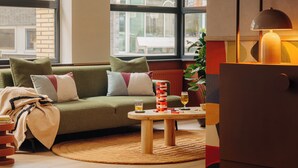 A cozy living room with a green sofa, a wooden coffee table, and a lamp. - Leonardo Hotel Hengelo City Center (Hengelo)