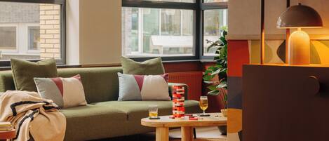 A cozy living room with a green sofa, a wooden coffee table, and a lamp.
