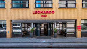 The exterior of the Leonardo Hotel with a brick facade, large windows, and a prominent entrance with a canopy. - Leonardo Hotel Hengelo City Center (Hengelo)