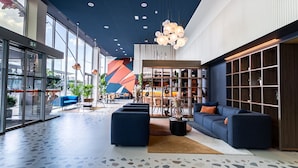 A modern lobby with a blue sofa, a coffee table, and a bookshelf.