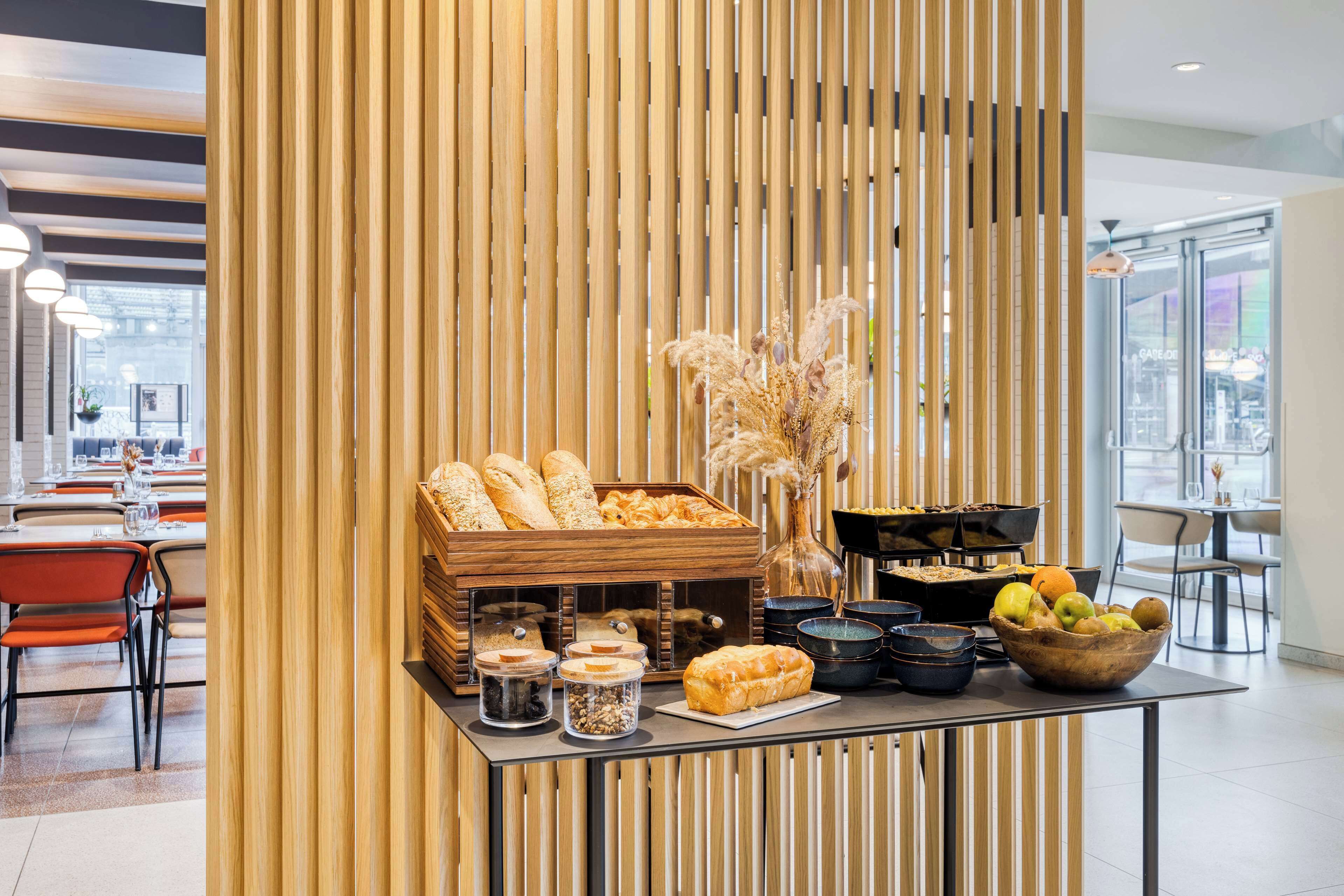 A buffet setup with bread, fruits, and condiments.