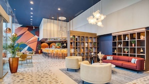 A modern lobby with a seating area, a bar, and a bookshelf.