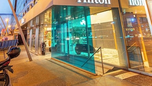 A modern building with a glass facade and the Hilton logo.