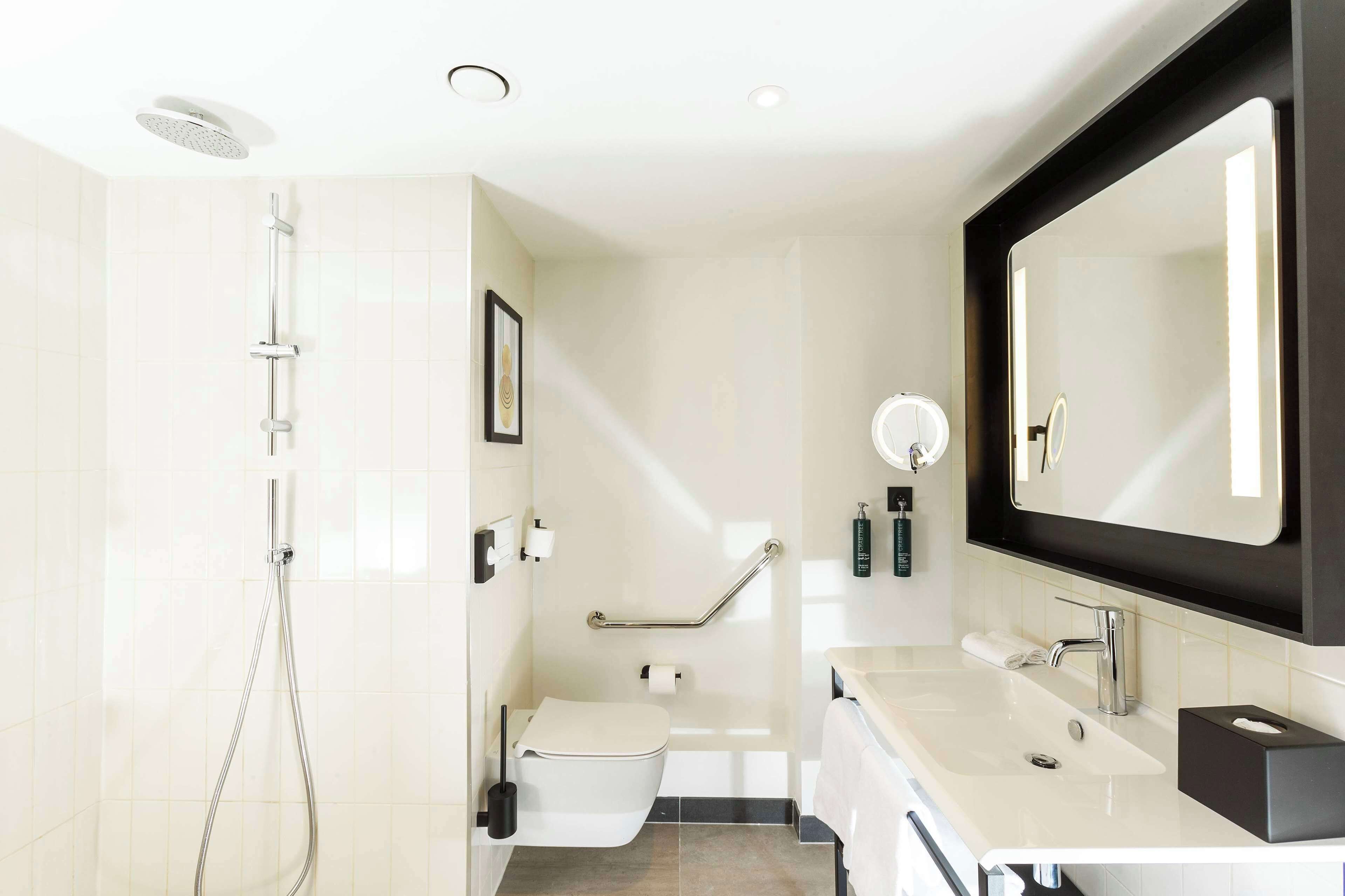 Une salle de bain moderne équipée d’une douche, de toilettes et d’un lavabo.