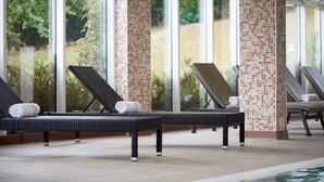 A poolside area with lounge chairs and a tiled wall. - Macdonald Cardrona Hotel, Golf & Spa (Peebles)