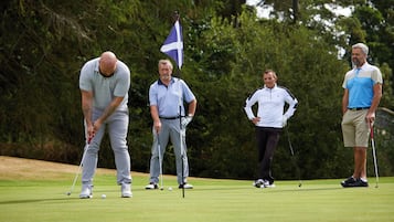 A golf course with players and a flag.