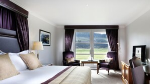 A hotel room with a large bed, two armchairs, a desk, and a television. - Macdonald Cardrona Hotel, Golf & Spa (Peebles)