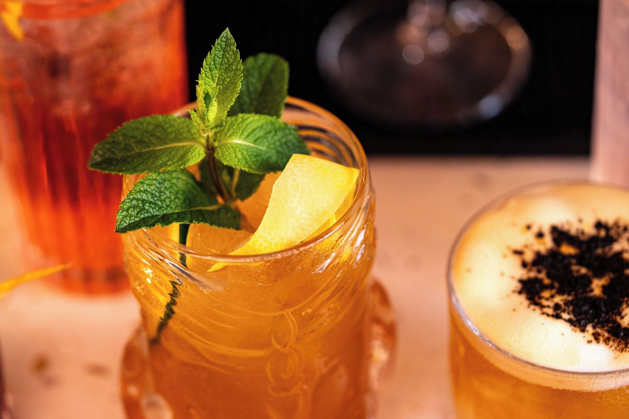 Un verre contenant une tranche de citron et quelques feuilles de menthe.