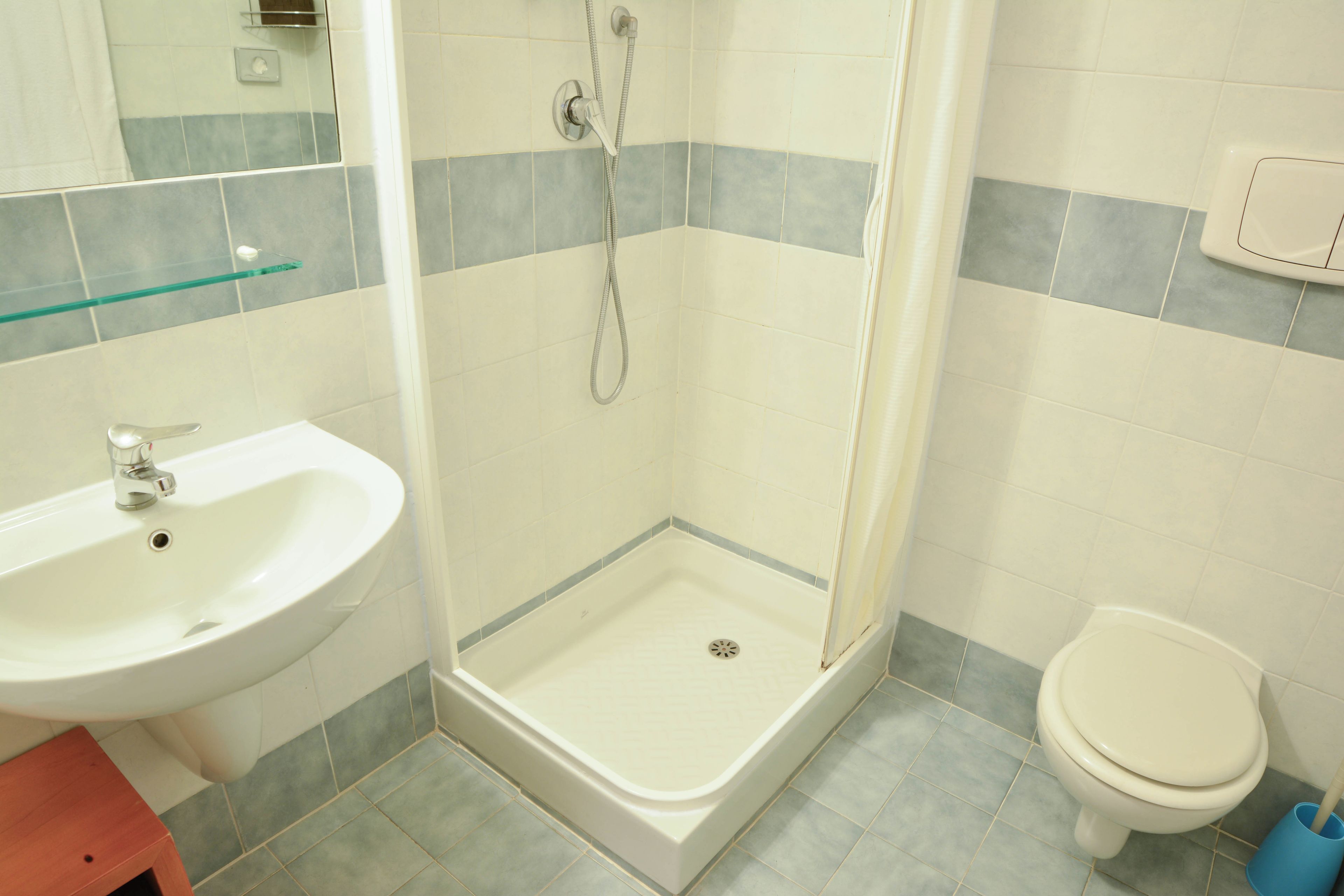 A bathroom with a shower, sink, and toilet.