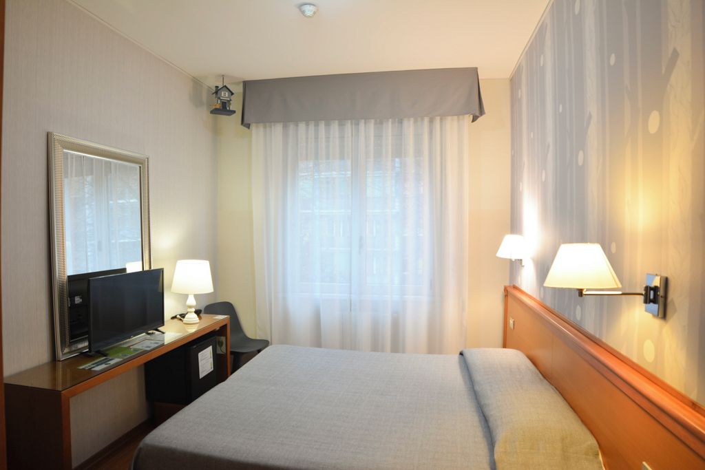 Habitación doble | Edredón, minibar, caja de seguridad en la habitación y escritorio 
