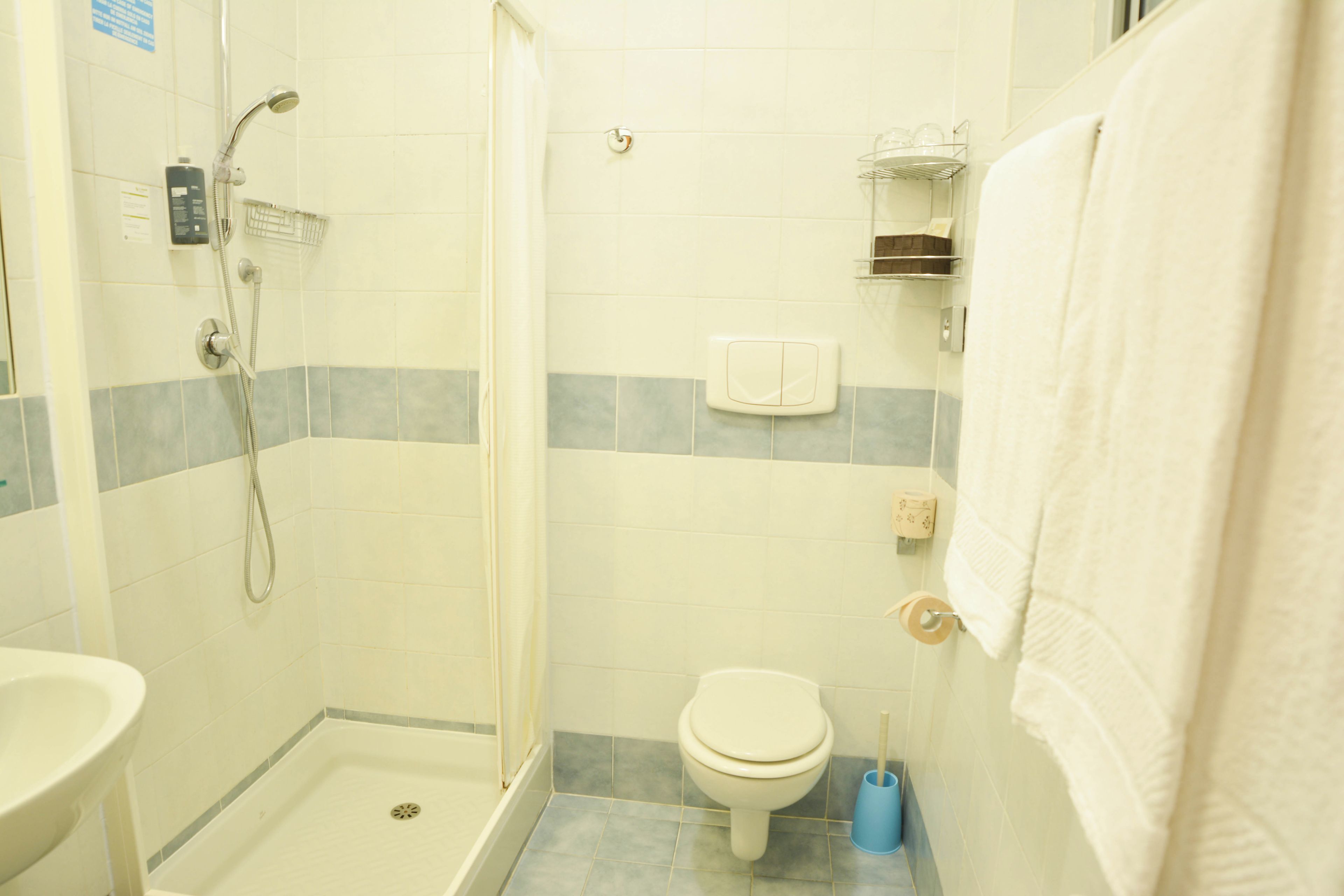 Un bagno con doccia, WC e lavandino.