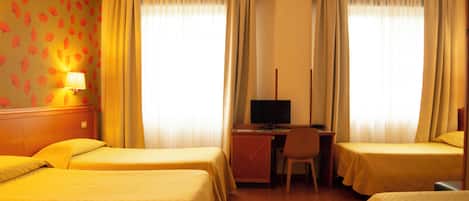 A hotel room with two beds, a desk with a computer, and a chair.