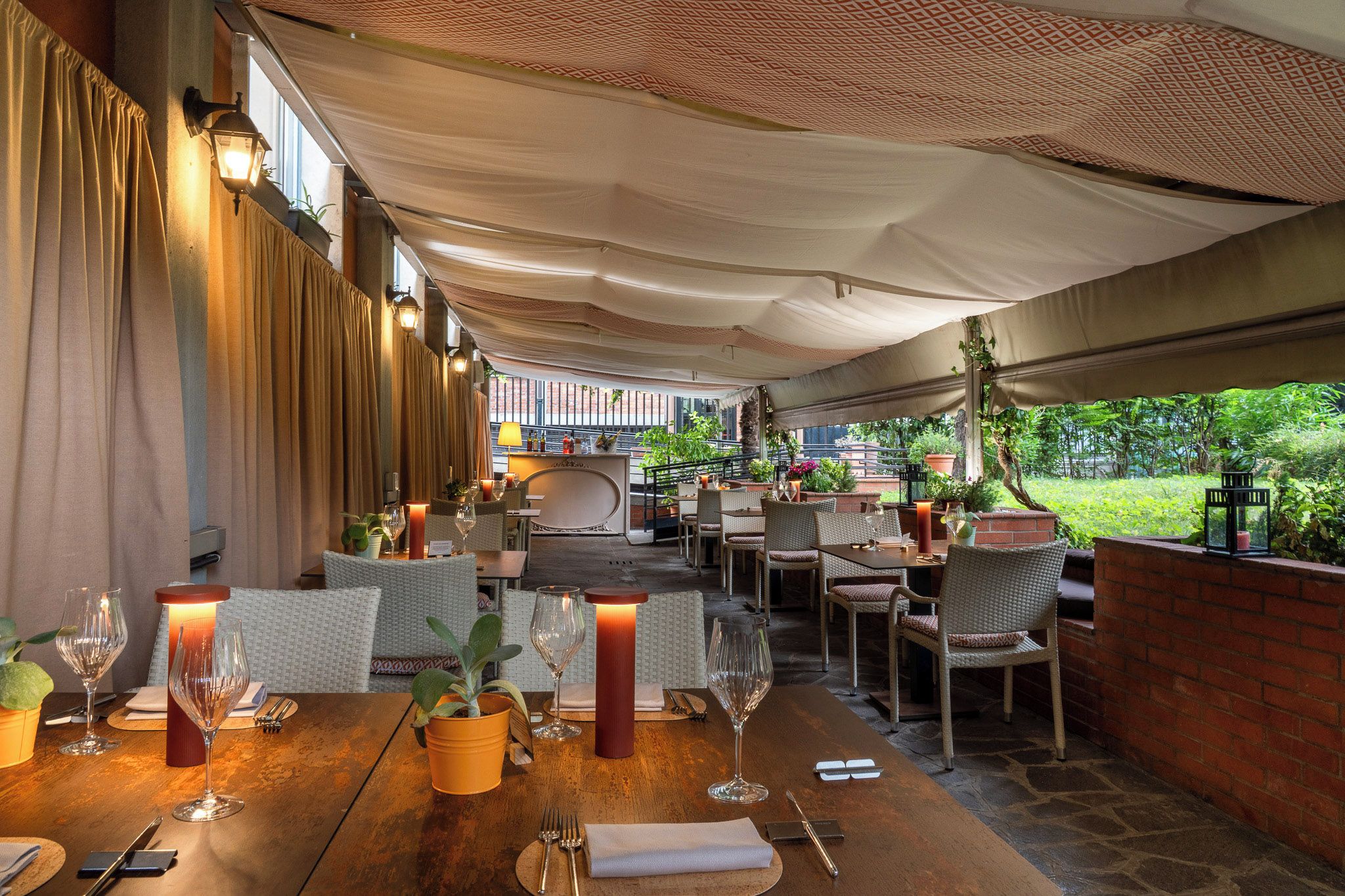 An outdoor dining area with tables, chairs, and ambient lighting.