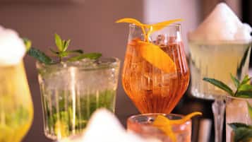 A variety of glassware with different beverages, garnishes, and ice cubes.