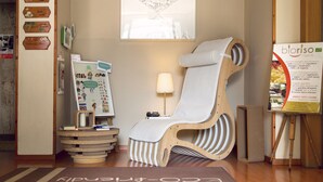 A room with a wooden chair, a small table with a lamp, and a poster on the wall. - eco Hotel Milano & BioRiso Restaurant (Milan)
