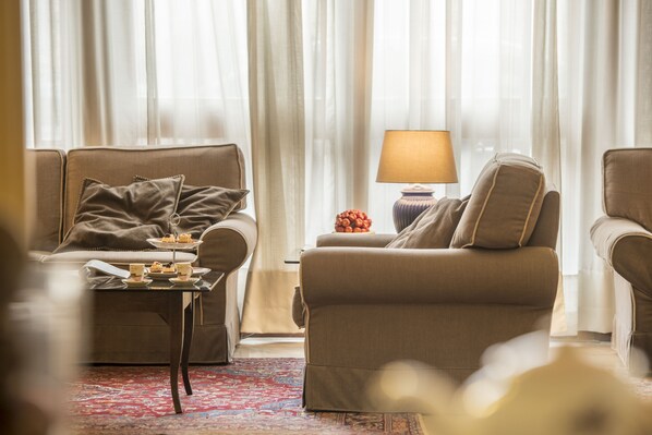 A living room with two sofas, a small table with a lamp, and a decorative vase. - Hotel Ambasciatori (Brescia)