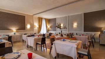 Un comedor con mesas dispuestas para comidas, iluminación ambiental y una decoración central.