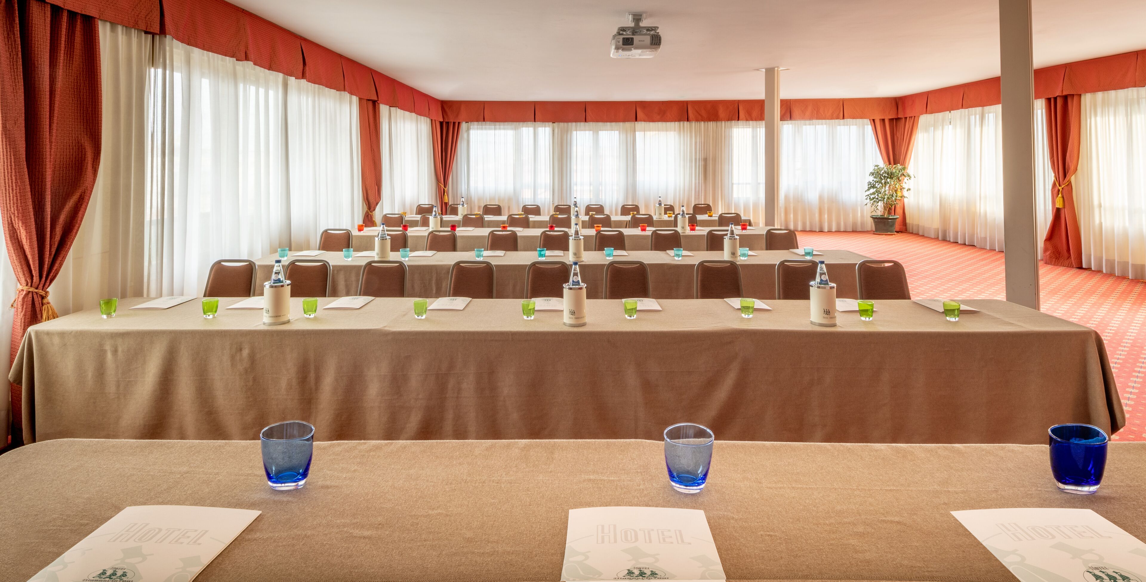 A conference room with a long table, chairs, and a projector.
