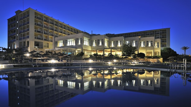 Un hotel de varios pisos con piscina y zona de estar al aire libre.