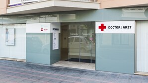 Entrada de un edificio con un letrero que dice 'Doctor Arzt' y un cartel de clínica dental.