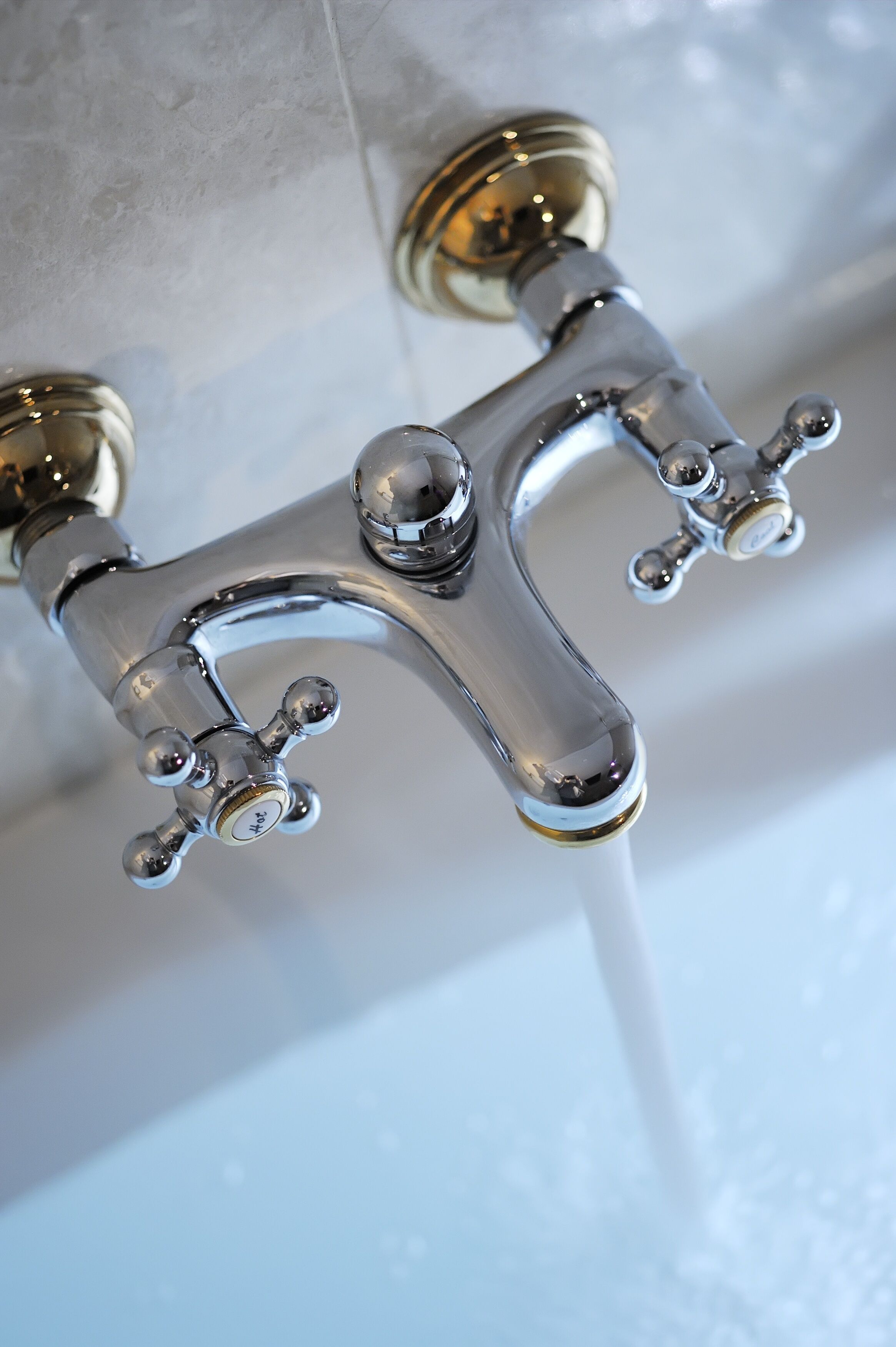 A chrome faucet with a lever handle and a separate hot and cold spout.