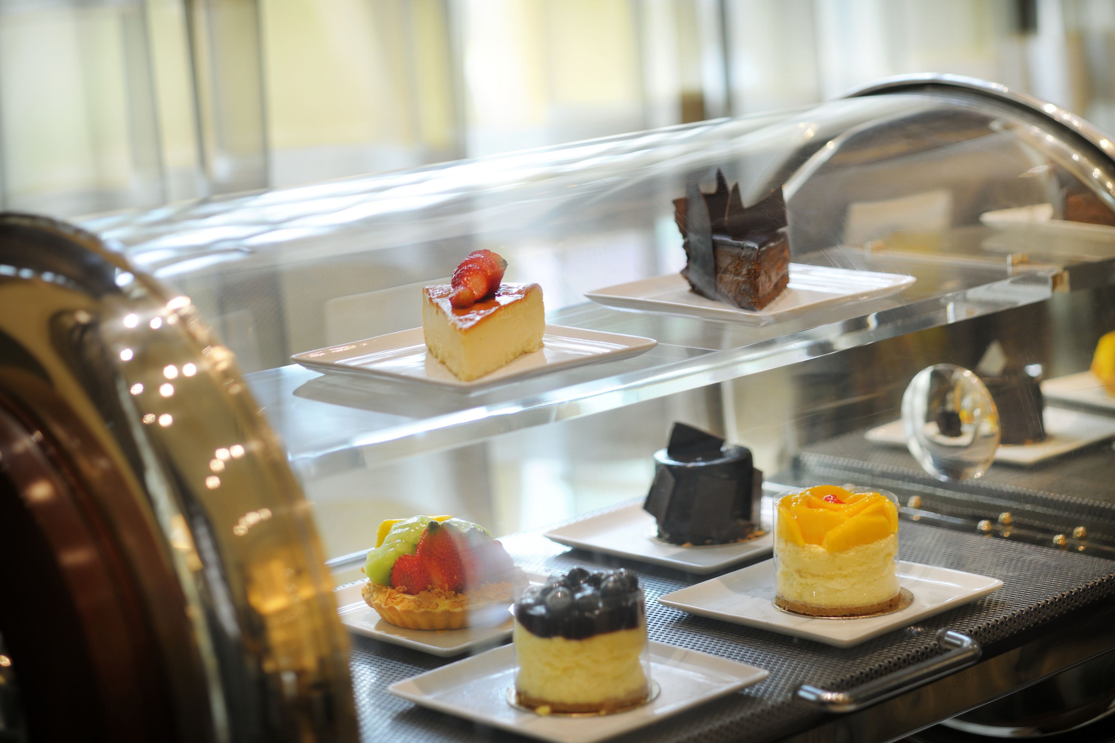 A dessert display case with various plated desserts.