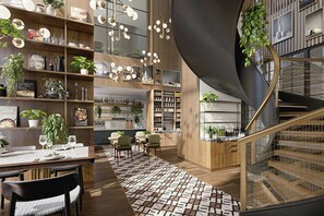 Ein modernes Interieur mit Essbereich, Bücherregalen und einer Wendeltreppe.