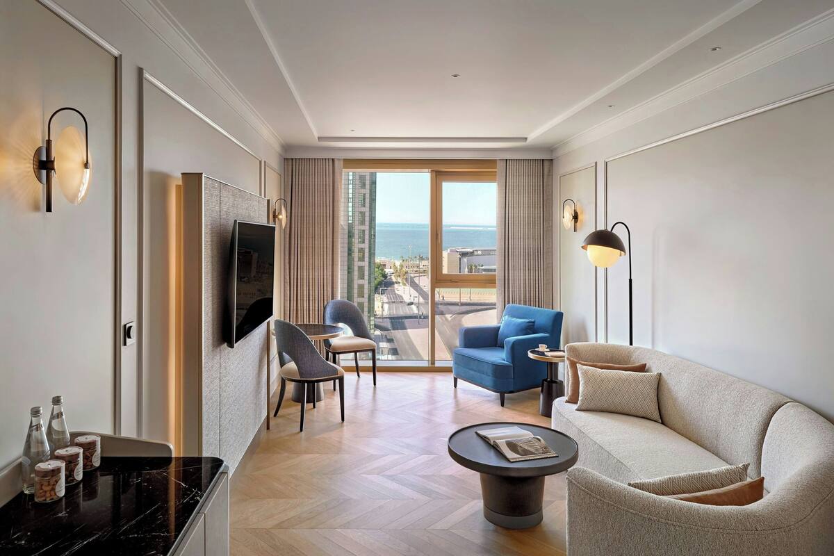 Une chambre d’hôtel moderne équipée d’un canapé, d’un fauteuil et d’une table à manger.