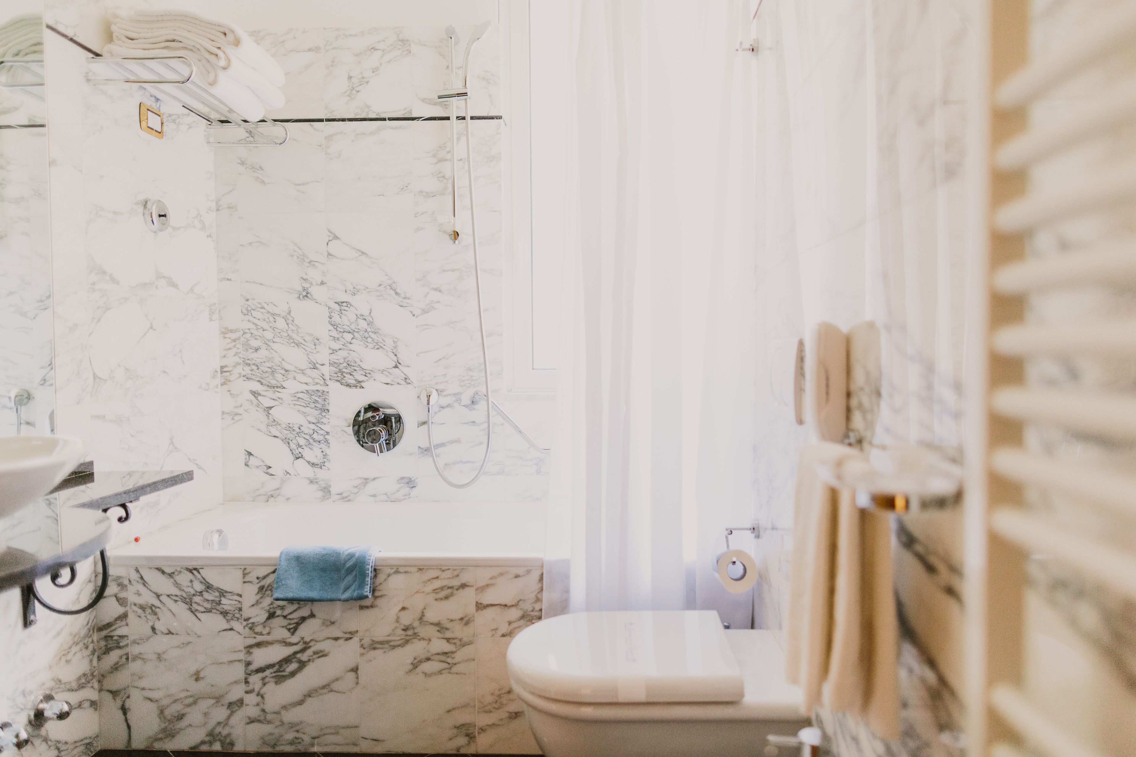 Ein Badezimmer mit einer Marmordusche, einer Toilette und einem Waschbecken.