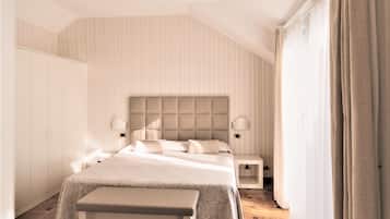 Un dormitorio moderno con una cama grande, mesitas de noche y un armario.