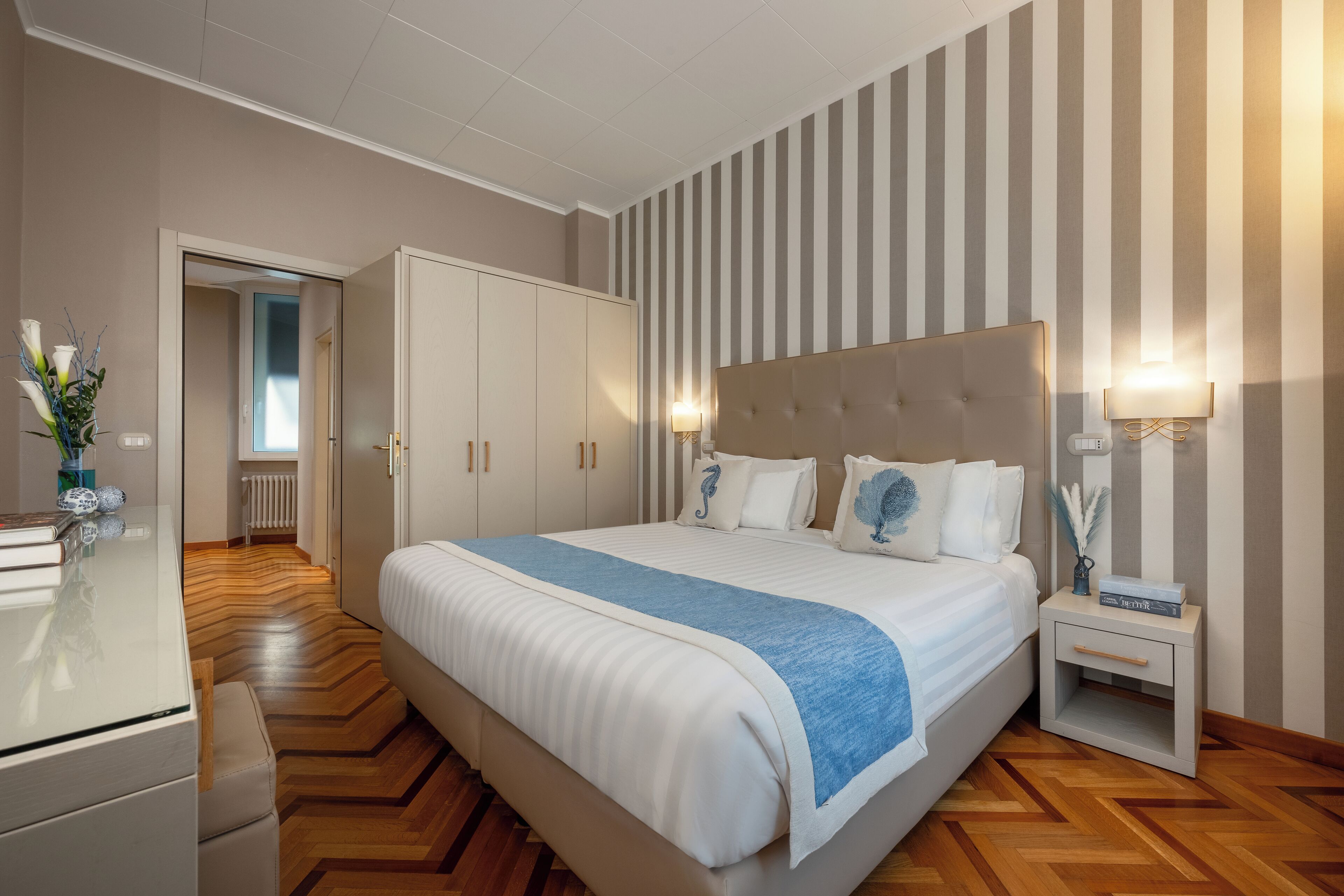 Ein modernes Schlafzimmer mit einem großen Bett, einer Kommode, einem Nachttisch und einer Heizung.
