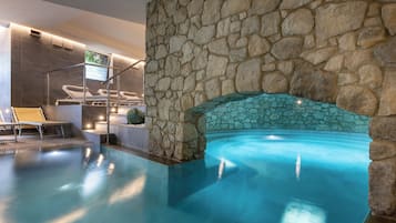 Una piscina techada, una piscina al aire libre de temporada, sombrillas