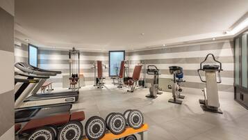 A modern gym with treadmills, weight machines, and dumbbells.