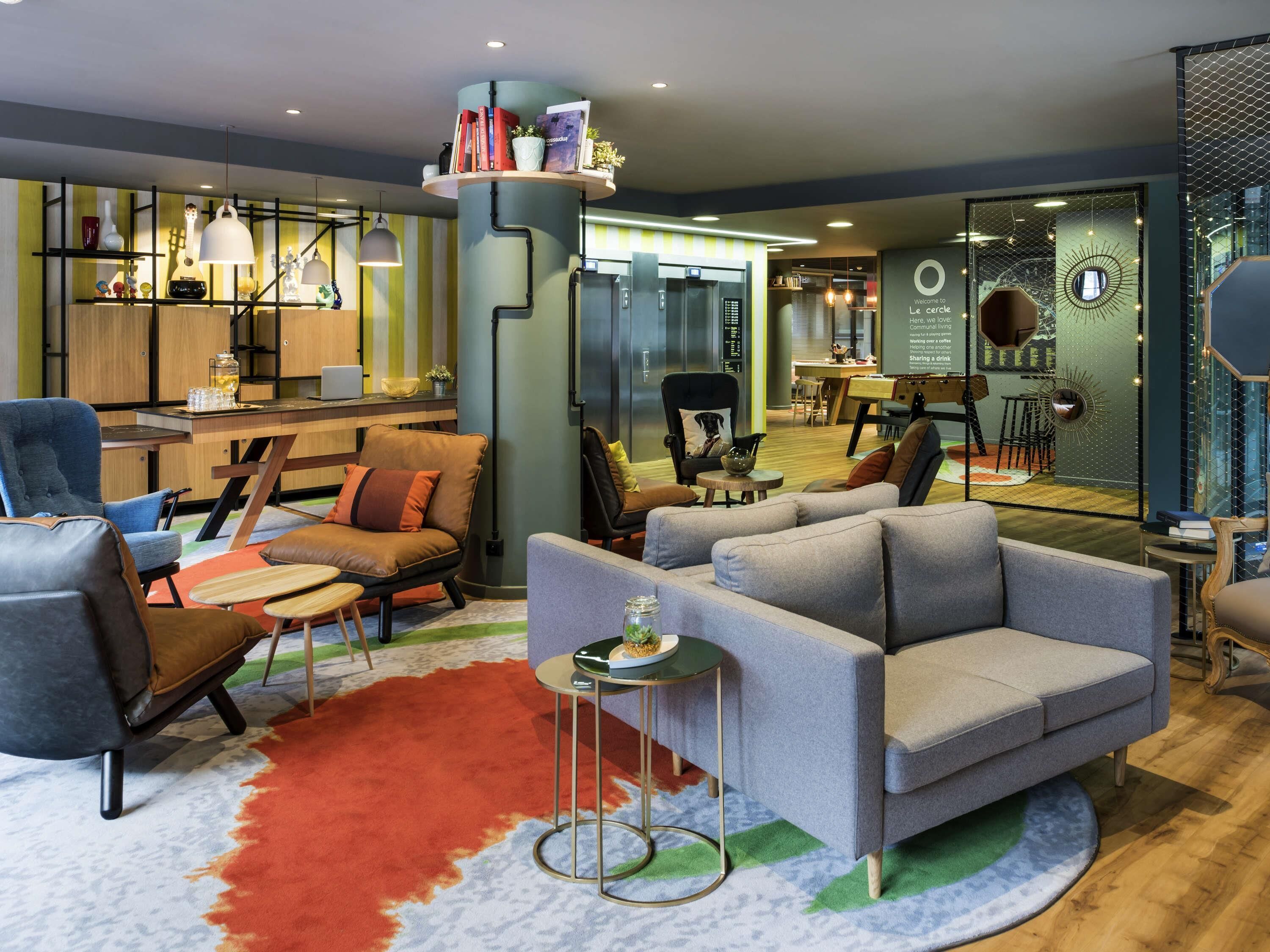 A modern lounge area with sofas, chairs, and a coffee bar.