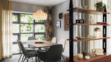 A modern dining area with a table, chairs, and a hanging light fixture.