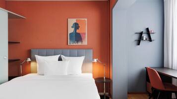 Une chambre d’hôtel avec un lit, des lampes de chevet, un bureau et une chaise.
