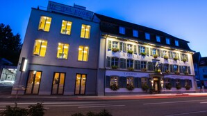 Un hotel con un cartel que dice "HOTEL ENGEL" y un restaurante llamado "TAVERNE RESTAURANT" en la planta baja.