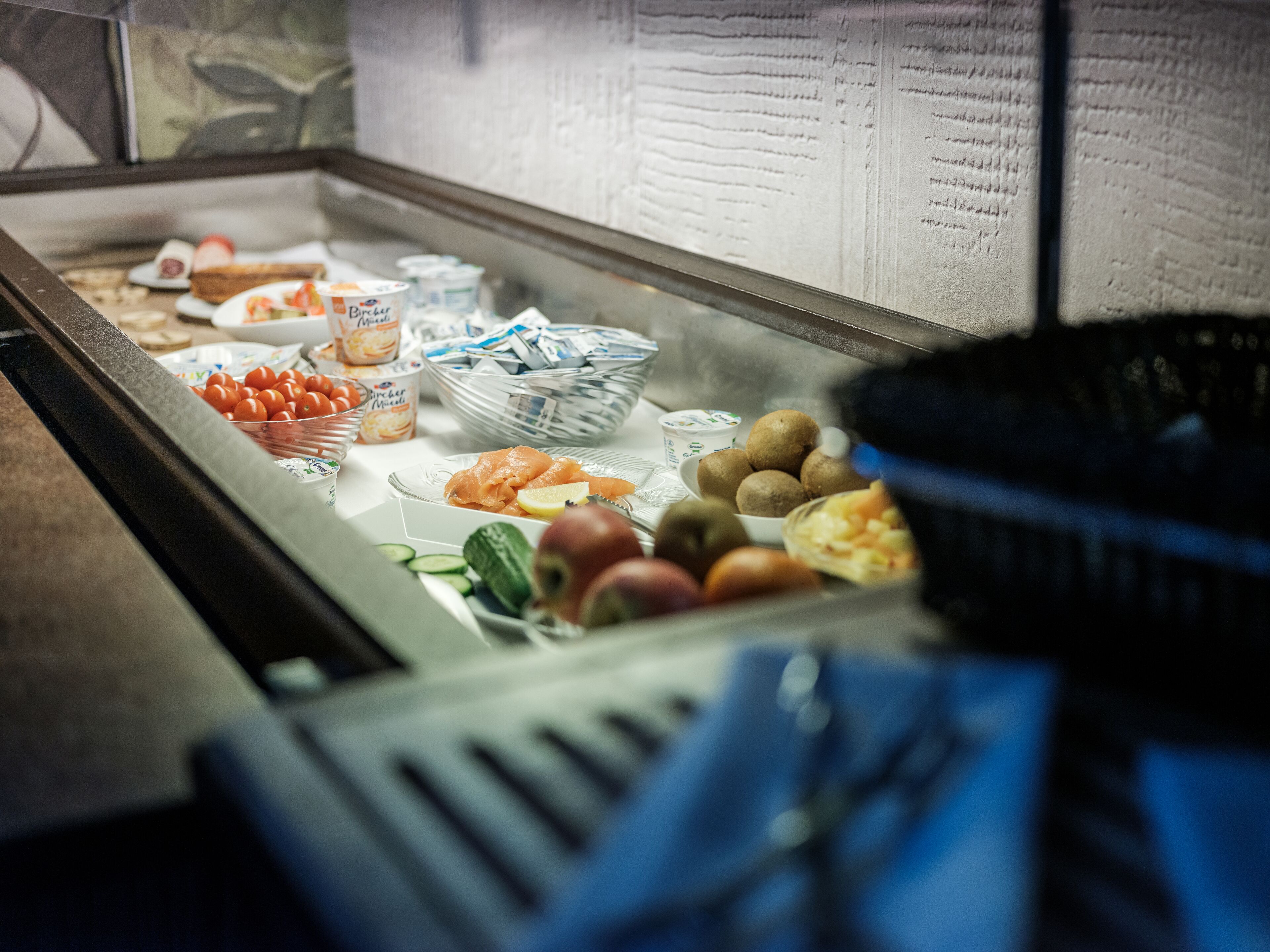 Un buffet proposant une variété d’aliments, notamment des fruits, des légumes et de la charcuterie.
