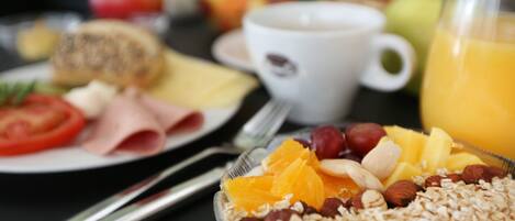 A breakfast setting with plates of food, a cup of coffee, and a glass of orange juice.
