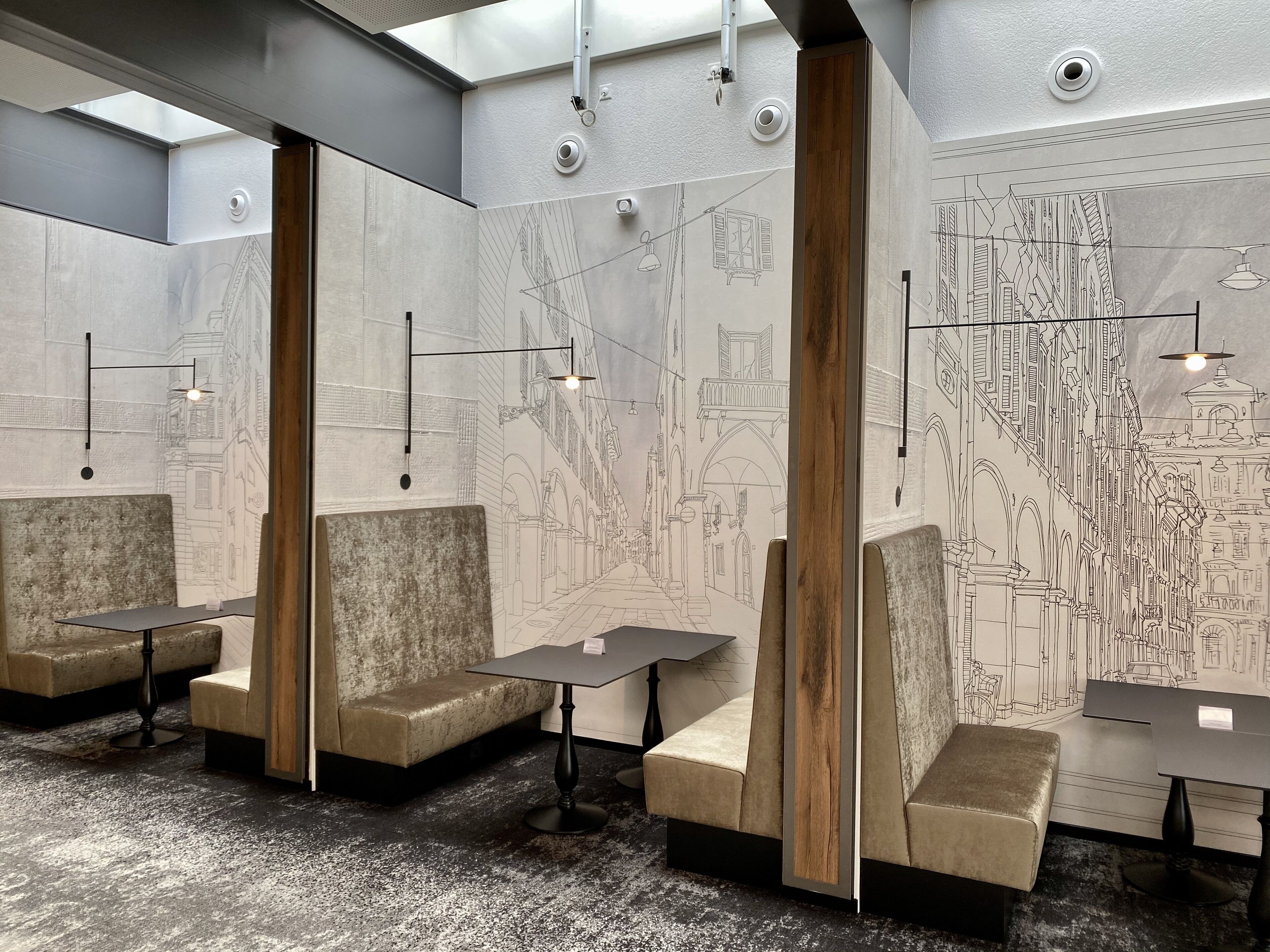 Un interior moderno con techos altos, iluminación empotrada y una columna de madera central.