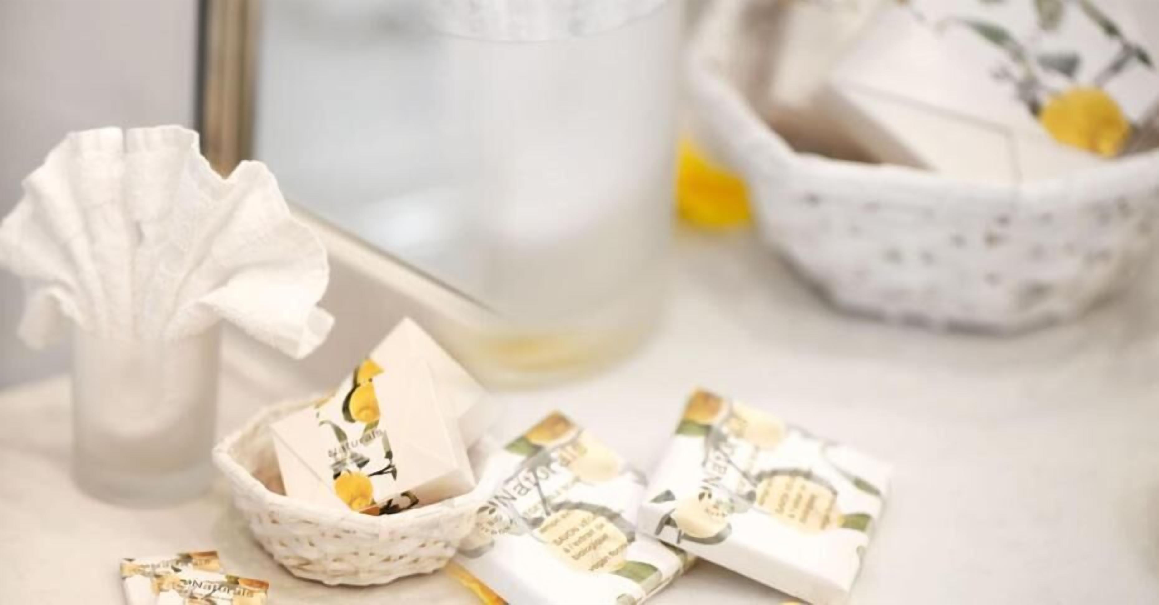 A basket with soap bars and a tissue roll on a table.