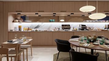 A modern kitchen with wooden cabinets, a marble countertop, and pendant lighting.