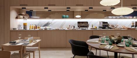 Una cocina moderna con armarios de madera, encimera de mármol e iluminación colgante.