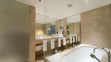 Ein modernes Badezimmer mit einer großen Badewanne, zwei Waschbecken und einem Spiegel.