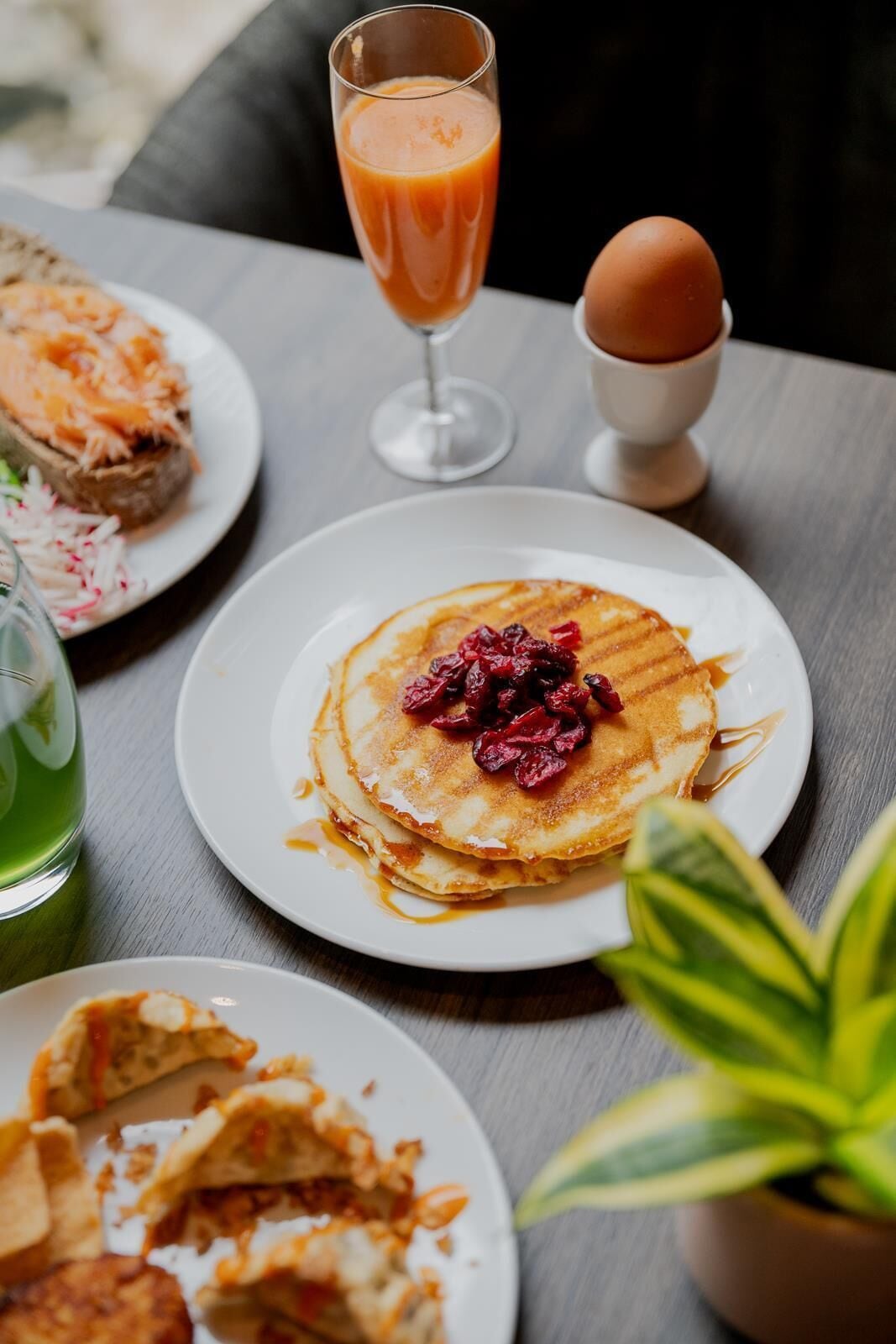 Un desayuno con tortitas, un vaso de zumo de naranja y una taza de café.