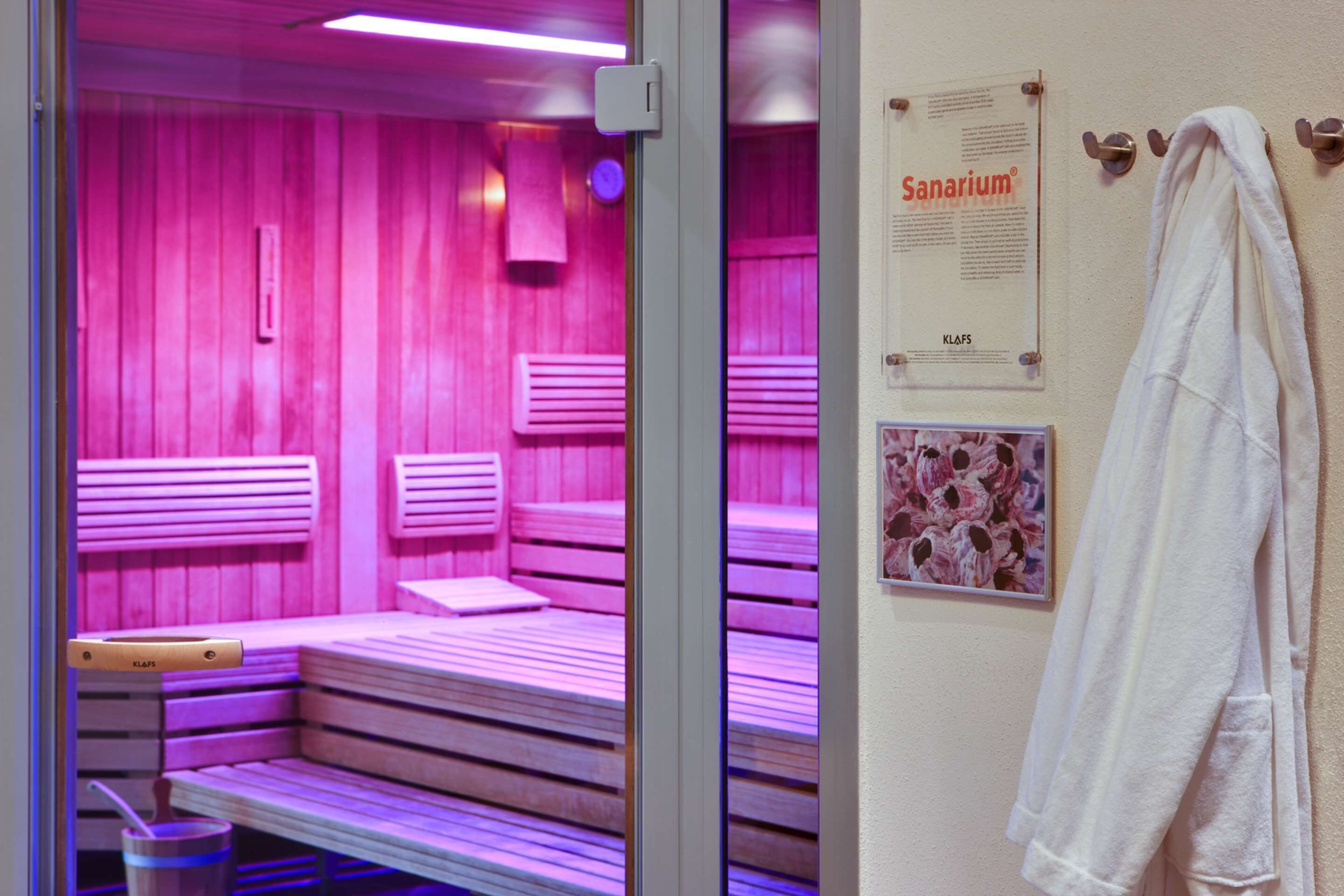 A sauna room with benches and a poster on the wall.